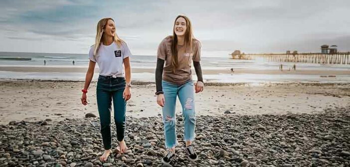 two young women walking up a beach - concept of accepting others