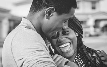 black and white photo of couple smiling and embracing - concept of falling back in love