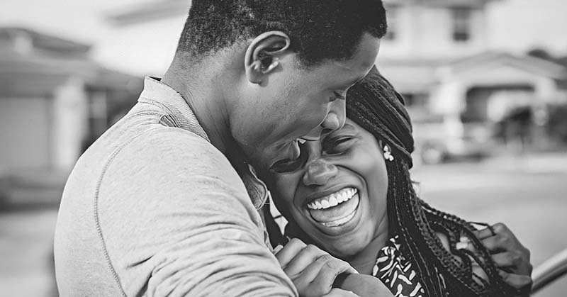 black and white photo of couple smiling and embracing - concept of falling back in love