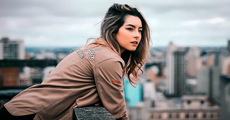 young woman on rooftop looking out over city skyline