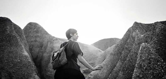 a woman walking through rock formations - concept of self-discovery