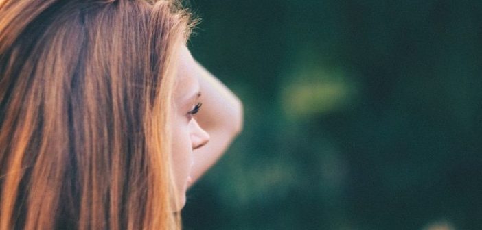 young woman looking out, worrying about what people are thinking