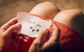 woman holding a thank you note