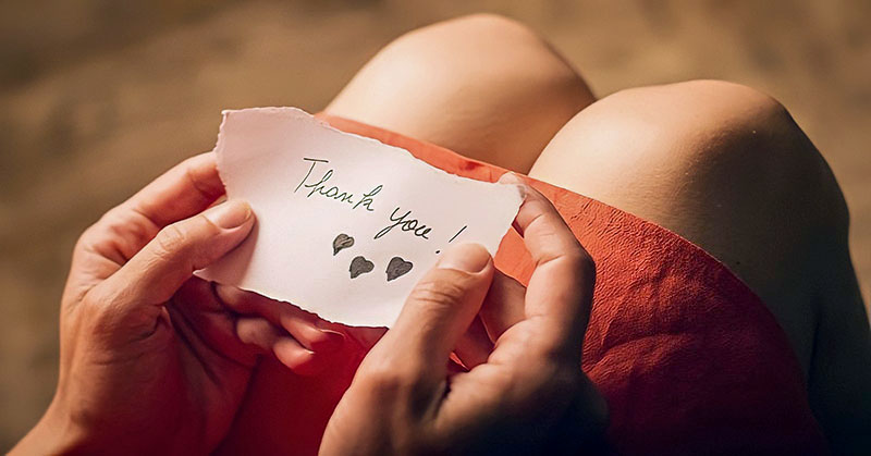 woman holding a thank you note