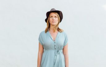woman with hat against pale background