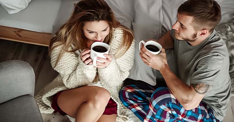 young couple drinking coffee on a couch illustrating loyalty in relationships