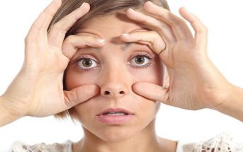 tired woman holding eyes open with fingers