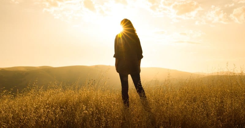 silhouette of woman against sunrise illustrating living life to the fullest