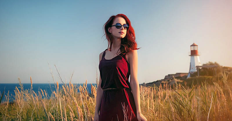 young woman with lighthouse in the background - concept of living one day at a time