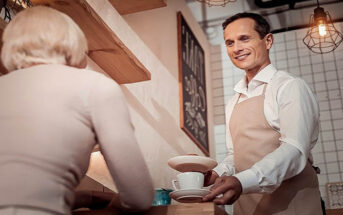polite waiter serving in a coffee shop