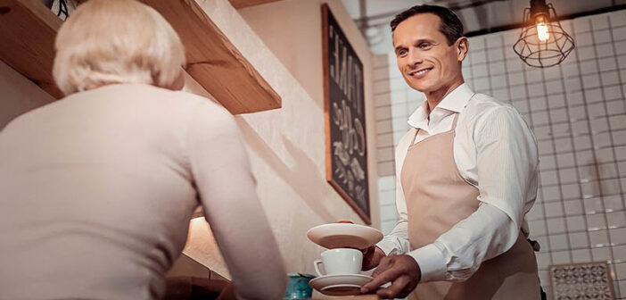 polite waiter serving in a coffee shop