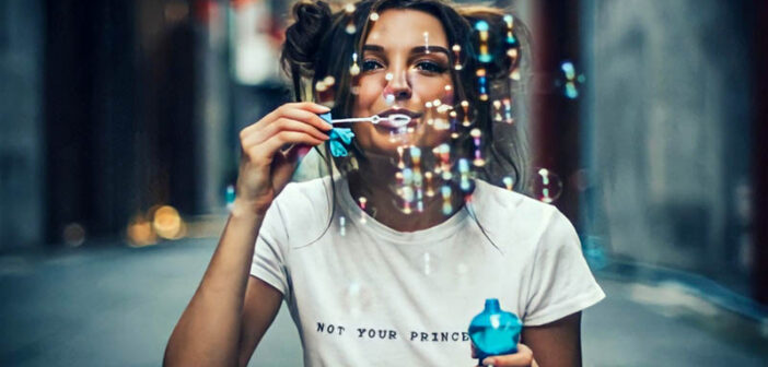 young woman enjoying life by blowing bubbles