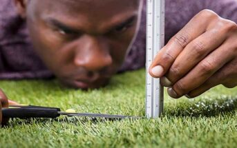 perfectionist man cutting grass with scissors and ruler