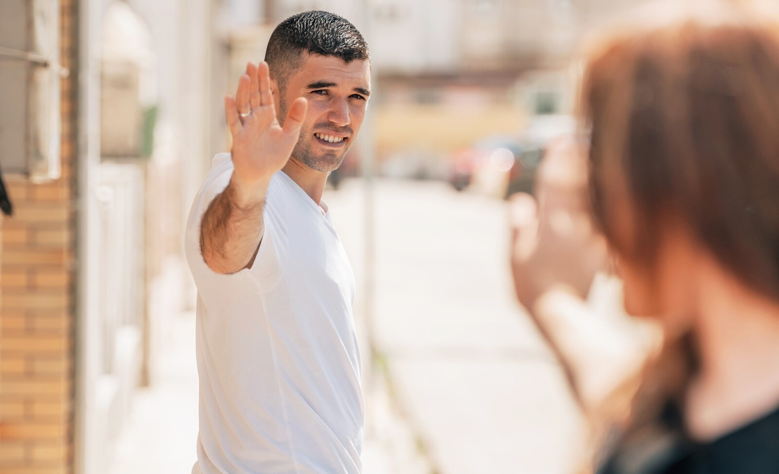 man waving goodbye to a woman