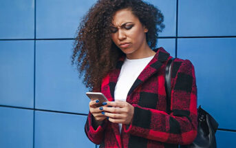 young woman looking at phone with confused expression illustrating the concept of breadcrumbing