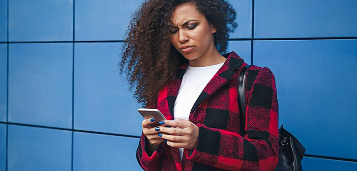 young woman looking at phone with confused expression illustrating the concept of breadcrumbing