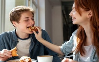 young woman feeding food to a man on a date