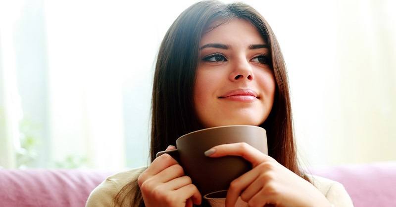 woman drinking coffee with smile on her face showing that she has become happy again
