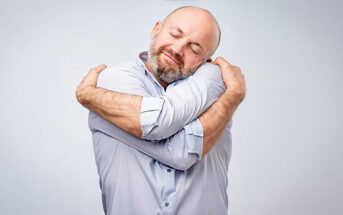 man hugging himself illustrating being kind to yourself