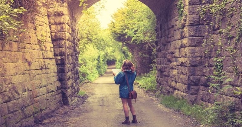 woman with map walking down country path illustrating trying to find yourself