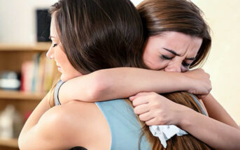 young woman hugging her crying friend and helping her through a breakup