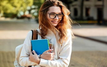young woman with glasses holding books illustrating a reserved person