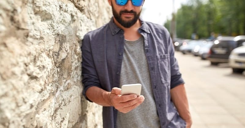 young man on phone texting a date