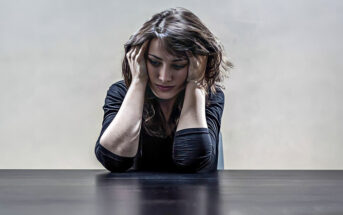 depressed woman holding head in her hands