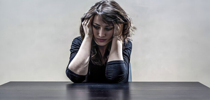 depressed woman holding head in her hands