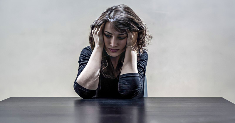 depressed woman holding head in her hands