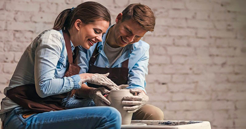 man and woman doing pottery together illustrating hobbies for couples