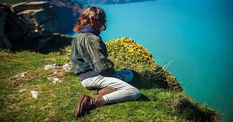 woman on clifftop thinking about her priorities in life