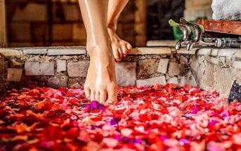 woman stepping into bath with rose petals - example of how being selfish is good