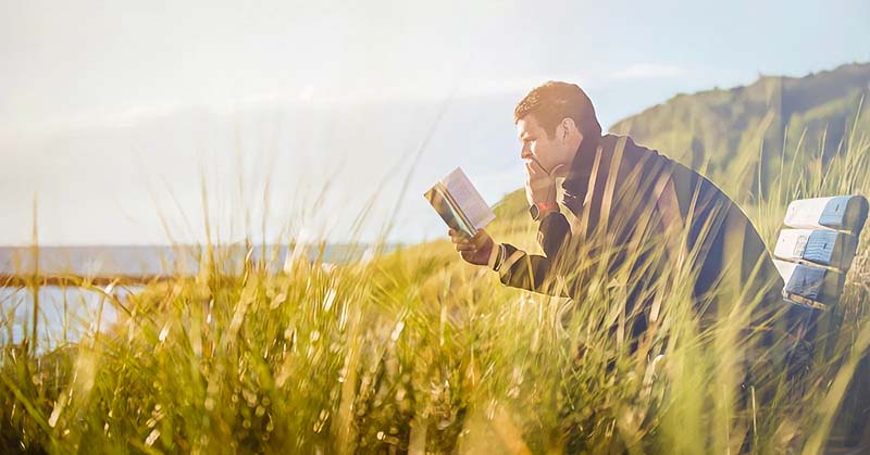 a man reading book alone in nature illustrating the concept of giving him space