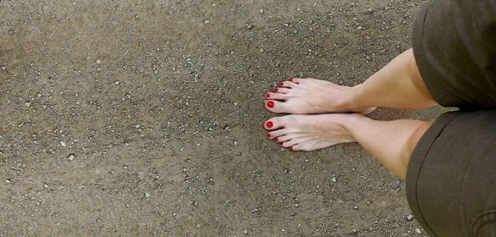 woman's bare feet on stony ground