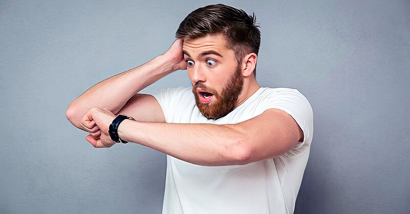 shocked man looking at watch to illustrate the importance of being on time