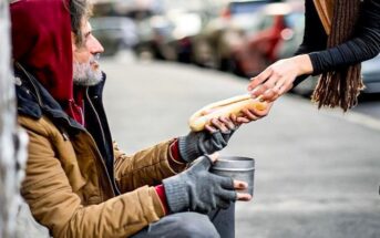 woman handing food to homeless person - illustrating being generous