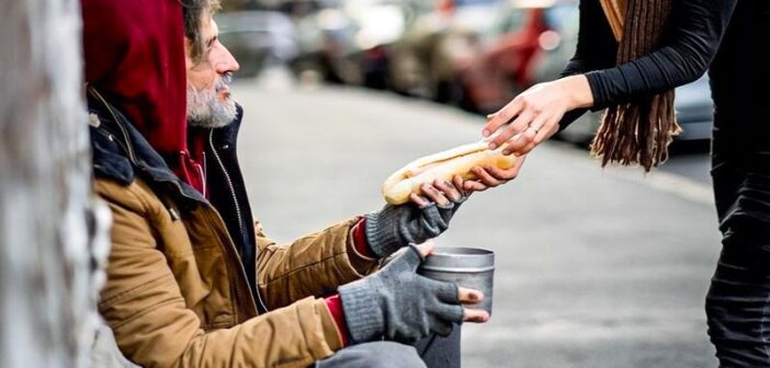 woman handing food to homeless person - illustrating being generous