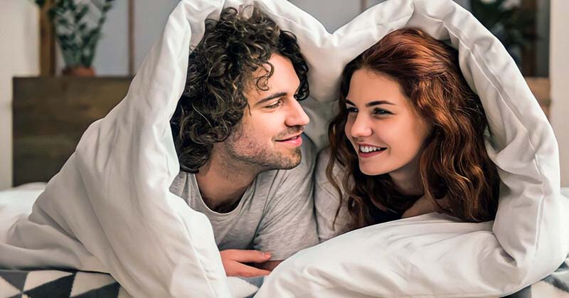 couple in bed asking each other questions