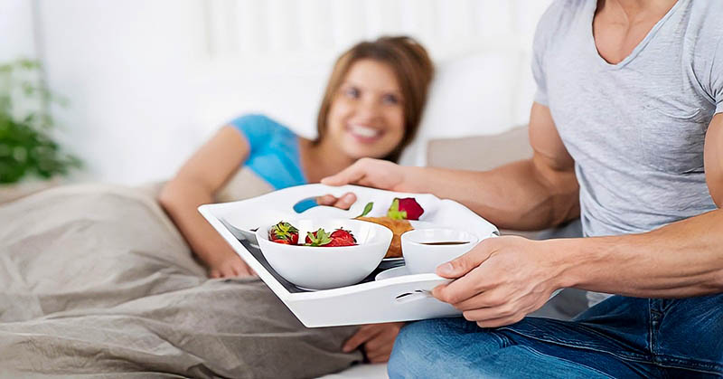 man bringing partner breakfast in bed - illustrating treating someone well