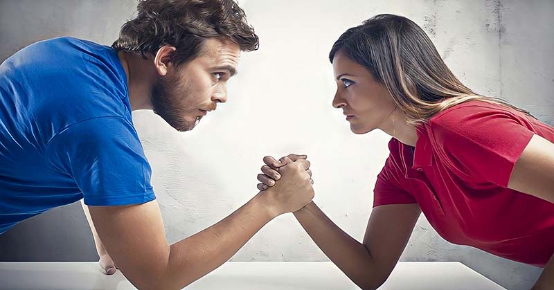 man and woman having arm wrestle because they always need to be right
