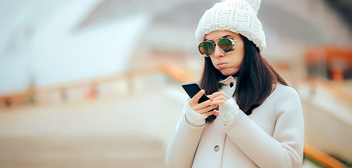 woman looking at phone wondering why she is still single