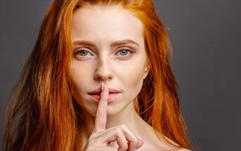 woman with finger over her lips to illustrate talking less
