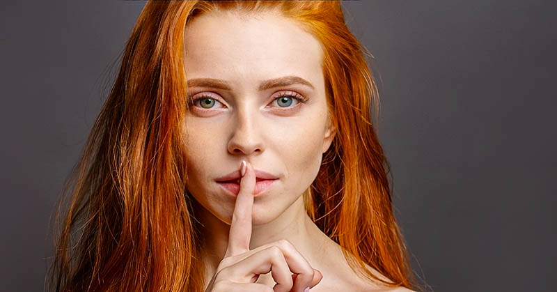 woman with finger over her lips to illustrate talking less