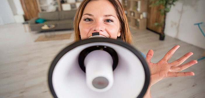 woman speaking into megaphone to illustrate someone who talks loud