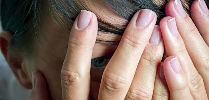 woman with hands over eyes showing that she feels like a disappointment