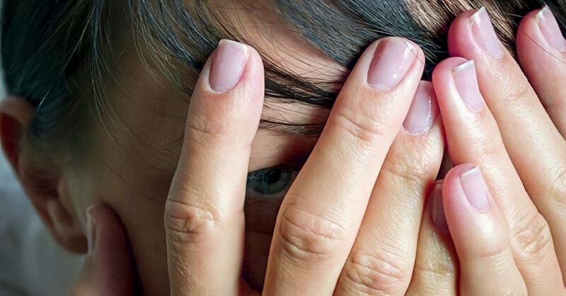 woman with hands over eyes showing that she feels like a disappointment
