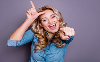 woman pointing and doing the loser sign on her head - illustrating putting others down