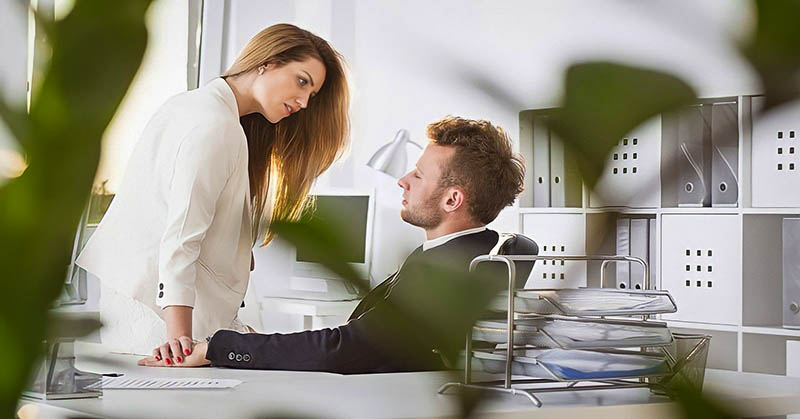 man and woman having an affair in an office