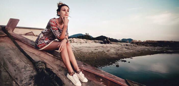 young woman sitting on shipwrecked boat feeling stuck in her life